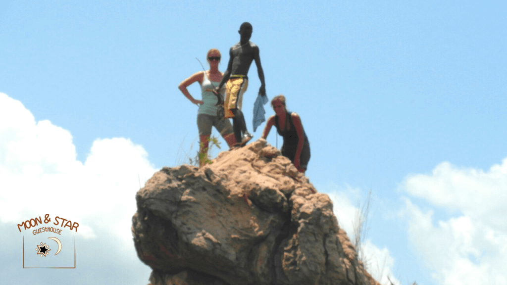 3 people on thelion rock at Bomfobiri park in Ashanti Ghana